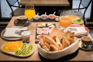 una mesa con una bandeja de comida y vasos de zumo de naranja en Hotel Rural Sagarlore, en Astigarraga