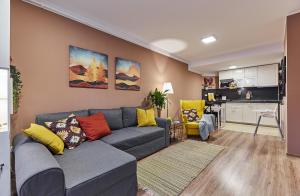 uma sala de estar com um sofá e uma cozinha em Sinaia Q Marie Apartment em Sinaia