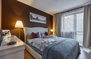 um quarto com uma cama grande e uma janela em Sinaia Q Marie Apartment em Sinaia