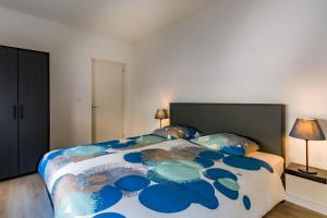 a bedroom with a large blue and white bed at Boven de ijsjes in Valkenburg