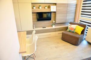 ein Wohnzimmer mit einem Stuhl und einem TV in der Unterkunft Najlepsze Miejsce - pokoje i apartamenty w Krakowie in Krakau