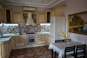 a kitchen with a white refrigerator and a table with chairs at Hotel Aquarius in Chornomorsk
