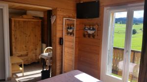 a room with a window and a tv on the wall at Hotel Restaurant LE YETI in Les Rousses