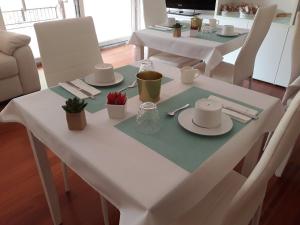 a white table with plates and napkins on it at A Casa di Grace in Basiglio
