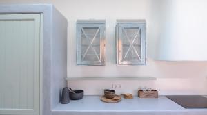 una cocina con 2 ventanas y cuencos en una encimera en Pénde Natura Residences, en Rámos