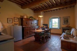a kitchen and living room with a table and a refrigerator at Podere San Luigi in San Gimignano