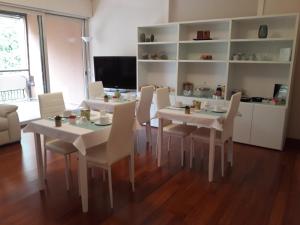 a dining room with white tables and white chairs at A Casa di Grace in Basiglio
