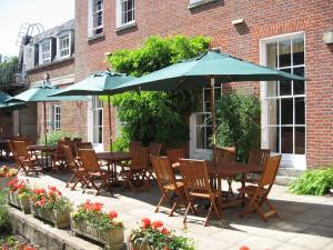 a group of tables and chairs with umbrellas at Lysses House Hotel in Fareham