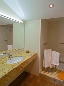 a bathroom with a sink and a large mirror at Hotel Pinxo in Santa Coloma de Farners