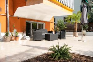 an outdoor patio with chairs and an umbrella at GarDar in Bolzano