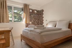 a bedroom with a bed and a brick wall at GarDar in Bolzano