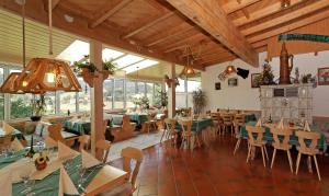 ein Restaurant mit Tischen und Stühlen in einem Zimmer mit Fenstern in der Unterkunft Landhaus Maria Bed&Breakfast in Regen