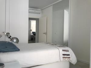 ネルハにあるEasy Nerja Carabeo (Calahonda Beach)の白いベッドルーム(ベッド1台、ランプ付)