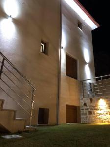 a building with stairs on the side of it at night at Thealos Rooms in Vourvourou