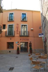 an orange building with chairs in front of it at Hotel Pinxo in Santa Coloma de Farners