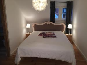 a bedroom with a white bed with a chandelier at Fabrikantenvilla in Erkrath