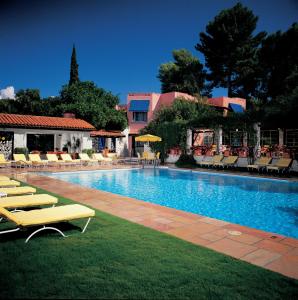 a swimming pool with lounge chairs and a resort at Arizona Inn in Tucson