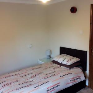 A bed or beds in a room at The Lodge Guest House 