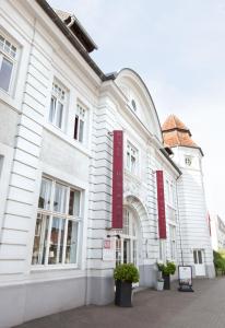 a white building with red signs on the side of it at Hotel Alter Kreisbahnhof in Schleswig