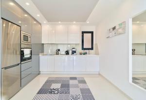 a kitchen with white cabinets and a checkered floor at Playa Elisa Bay - Mil Palmeras in Pilar de la Horadada