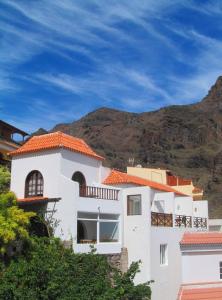 un edificio blanco con una montaña en el fondo en Casa Estefano Policarpo, en Valle Gran Rey