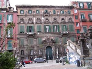 un vecchio edificio in una città con auto parcheggiate di fronte di Casa Margot a Napoli