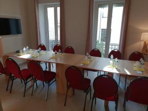 una sala de conferencias con una mesa grande y sillas rojas en Hotel Cannes Croisette, en Cannes
