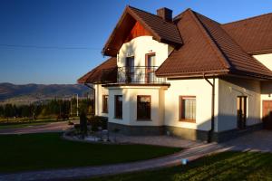 a large white house with a brown roof at Apartament na Falsztynie in Falsztyn