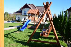 a swing set in the yard of a house at Apartament na Falsztynie in Falsztyn