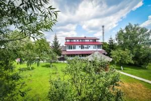 a large house on a green field with trees at Villa Bravo Breaza in Breaza