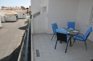 Un patio con una mesa y sillas en un balcón. en Residencial El Pinet Beach, en La Marina