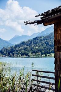 uma casa com vista para um lago e montanhas em Seehotel Enzian em Weissensee