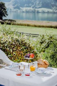 a white table with drinks and a basket of fruit at Seehotel Enzian in Weissensee