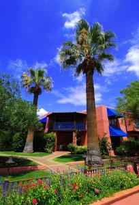 a house with palm trees and flowers in front of it at Arizona Inn in Tucson +25 photos