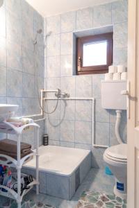 a bathroom with a tub and a toilet and a sink at Kuća Za Odmor Jovanović in Gornja Koprivna