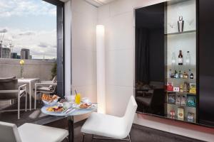 
a kitchen with a table, chairs and a refrigerator at ME London by Melia in London
