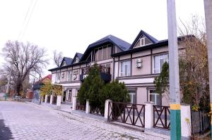a white and black house on a cobblestone street at Pride Hotel in Taraz
