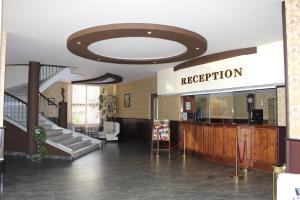 eine Lobby mit einer Treppe und einem Schild, das die Rezeption liest in der Unterkunft Hotel Trakia in Pasardschik