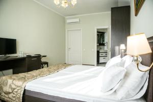 a bedroom with a bed with a desk and a lamp at Churchill-Inn in Vinnytsya