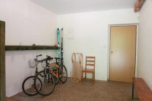 zwei Fahrräder, die in einem Zimmer mit Stuhl geparkt sind in der Unterkunft Apartmány U šneka in Železná Ruda