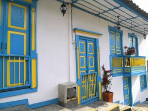 a house with blue and yellow doors and a television at Hotel Salento 1842 in Salento