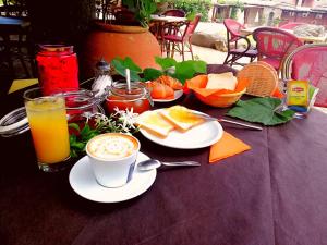 un tavolo con una tazza di caffè e un piatto di cibo di S'Incantu Resort a Villasimius Altre 20 foto