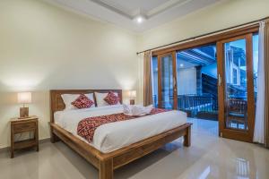 una camera con un grande letto e un balcone di Darba Guest House Ubud ad Ubud