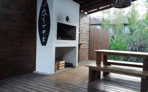 porche de madera con banco y chimenea en Salitre solo para parejas y familias, en La Pedrera