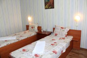 two twin beds in a room with two lamps at Hotel Trakia in Pazardzhik