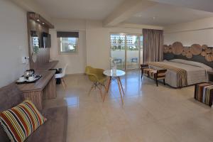 a hotel room with a bed and a living room at Nelia Beach Hotel & Spa in Ayia Napa