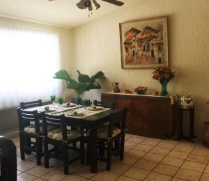 a dining room with a table with chairs and a plant at Condominio junto a la cañada Eca do Queiros in Guadalajara
