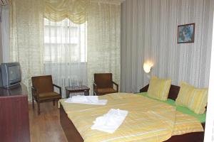 a hotel room with a bed and a tv at Hotel Trakia in Pazardzhik