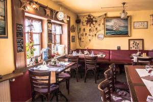 a dining room with tables and chairs in a restaurant at Gaststaette & Pension Schinkenkrug in Hinrichshagen