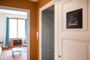 リヨンにあるHonorê - Suite Jacobinsのオレンジ色の壁とドアが特徴の客室です。